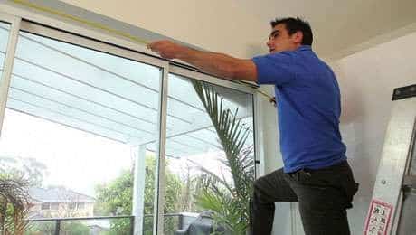 Man showing how to measure windows for blinds
