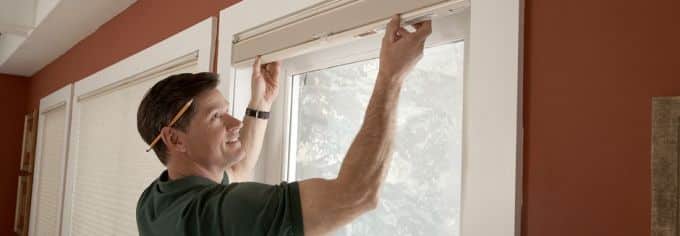 Man showing how to install blinds in the home.