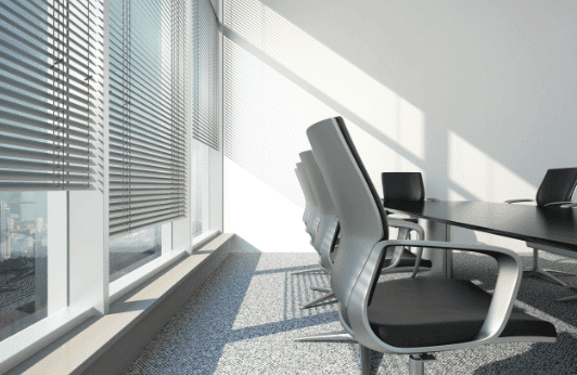 Line of office chairs next to Venetian blinds