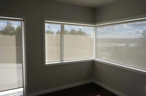 Home Vision Blinds client's room shows three windows that have sunscreen roller blinds Auckland in use.