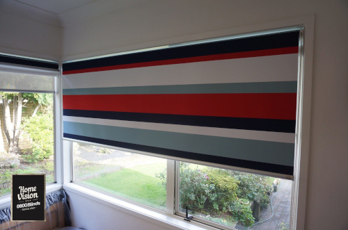 Home Vision Blinds client's bedroom featuring red, white and blue horizontal stripes on a fabric roller blind Auckland.